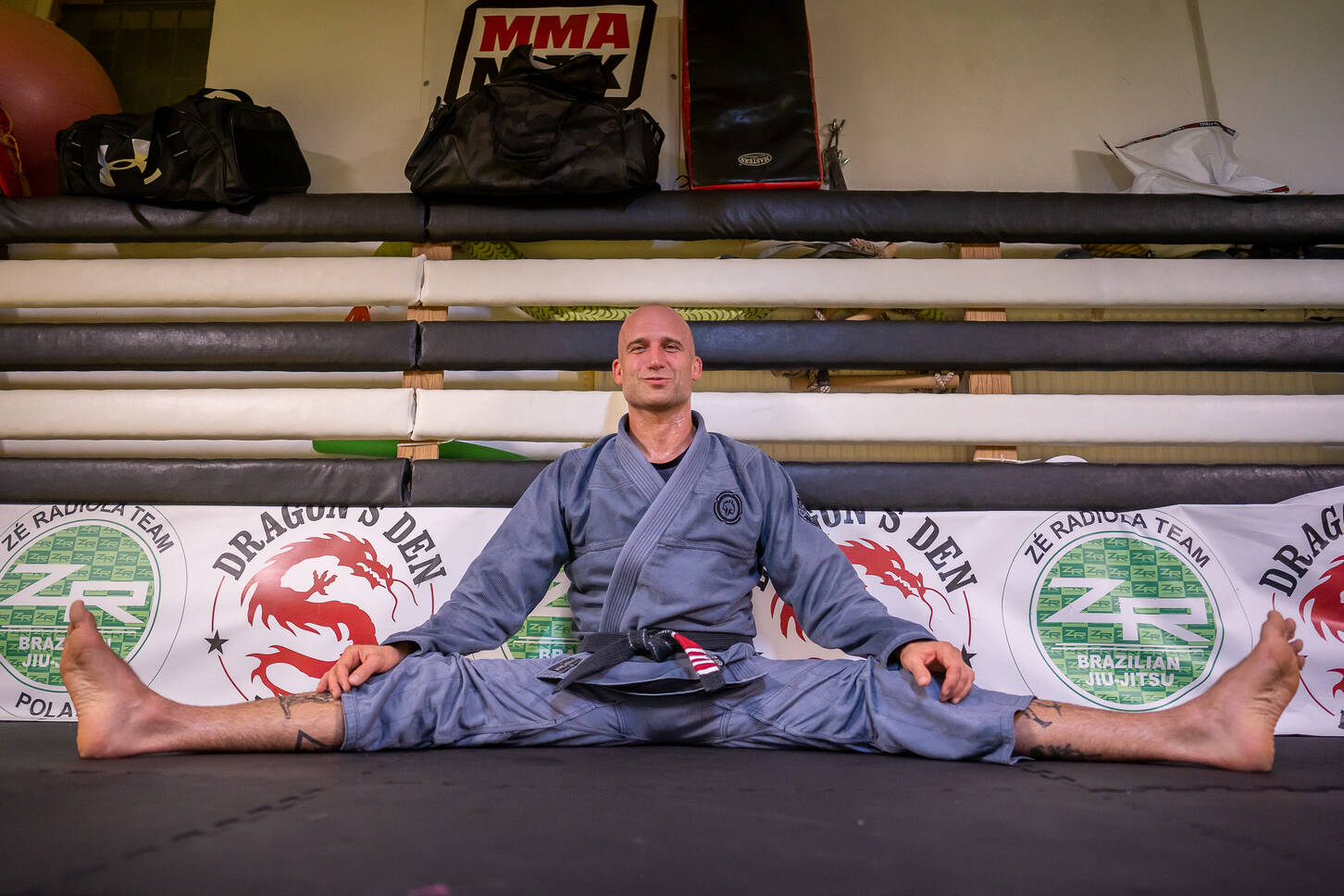 BJJ team seating at the platform holding medals and trophies