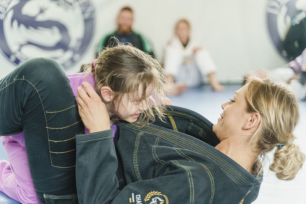 Women in Gi with a girl in Gi